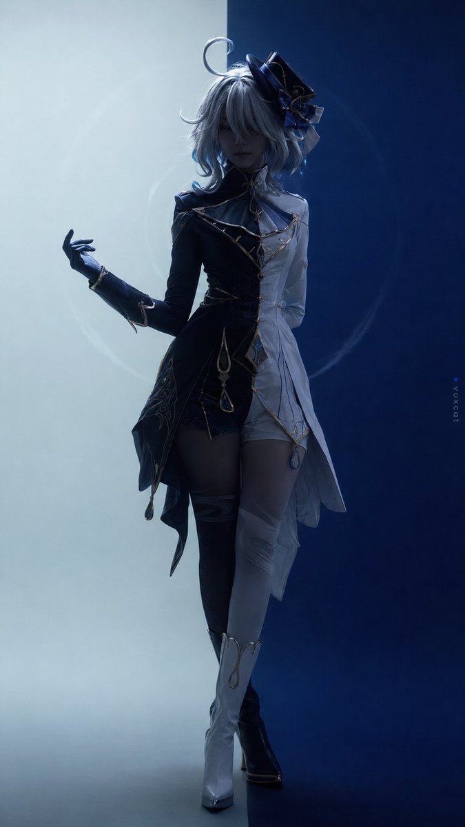 一位成年女性真人 COS，明确扮演《原神》芙宁娜的真人化版本。她佩戴银白偏冷的短发假发，发尾和内层带浅水蓝色，整体为略不