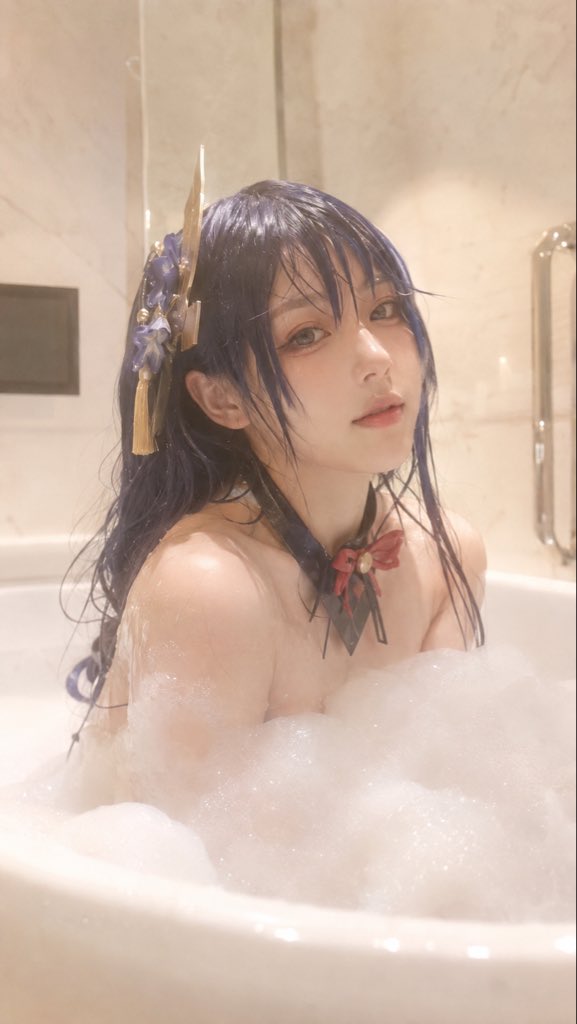 明确成年的东亚女性，坐在白色浴缸中泡泡浴，浓密白色泡沫自然覆盖身体，湿发贴在脸侧与肩颈，神情放松，轻微直视镜头。生活感私
