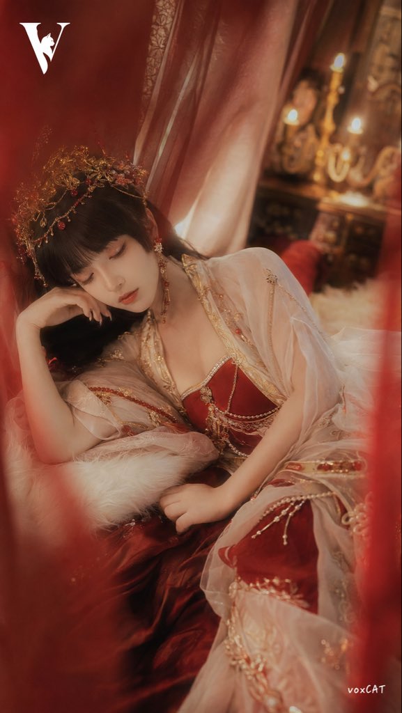一位成年女性角色，东方古典美人气质，黑色齐刘海长发，精致白皙肌肤，佩戴华丽金色头饰、红色珠宝发饰与流苏耳坠。身穿红白配色