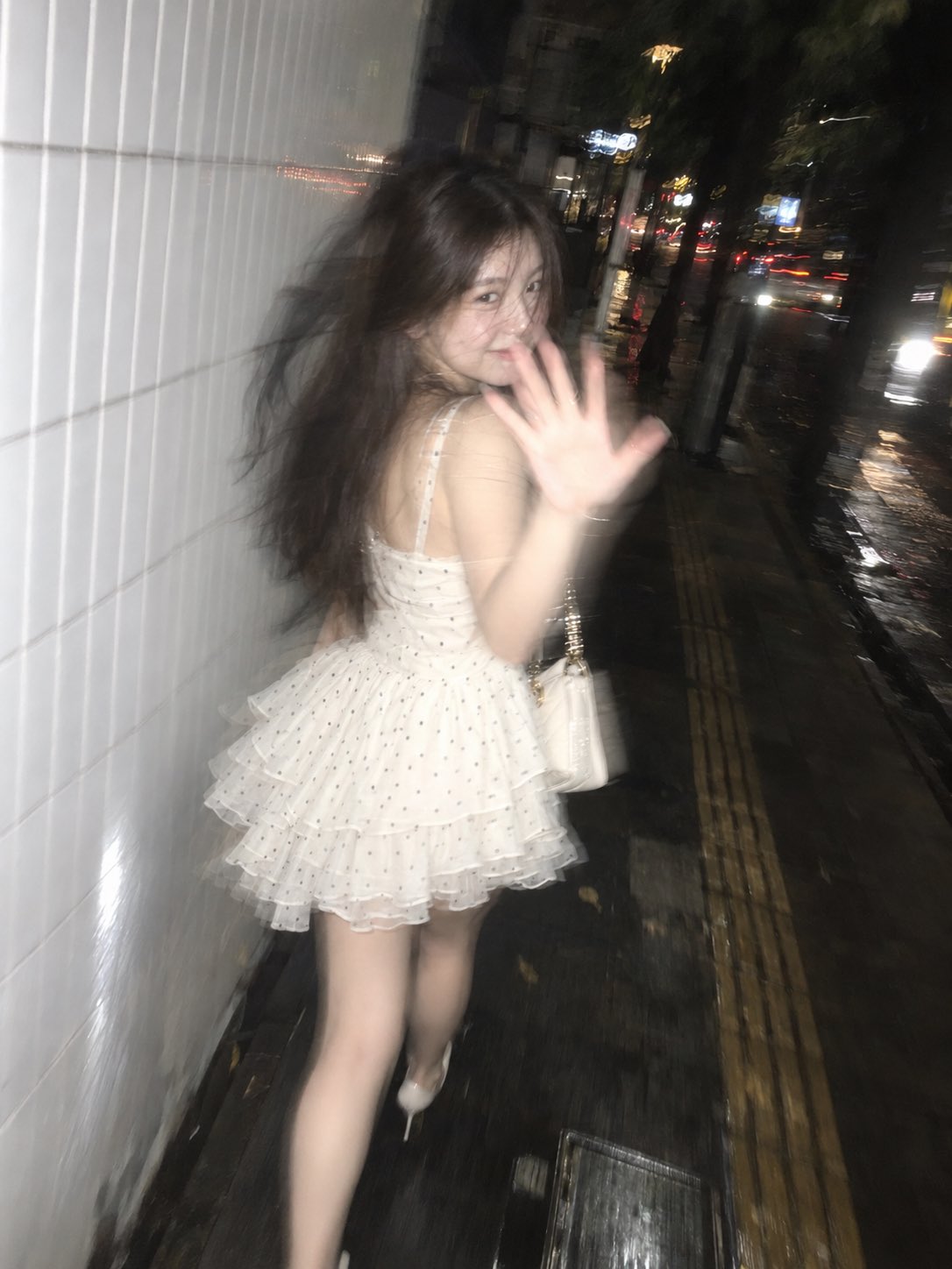 超现实主义偷拍智能手机照片,3:4纵向。原版不可识别的年轻女子在夜间雅加达人行道上,靠着白色瓷砖墙。中途行走,半侧脸,转