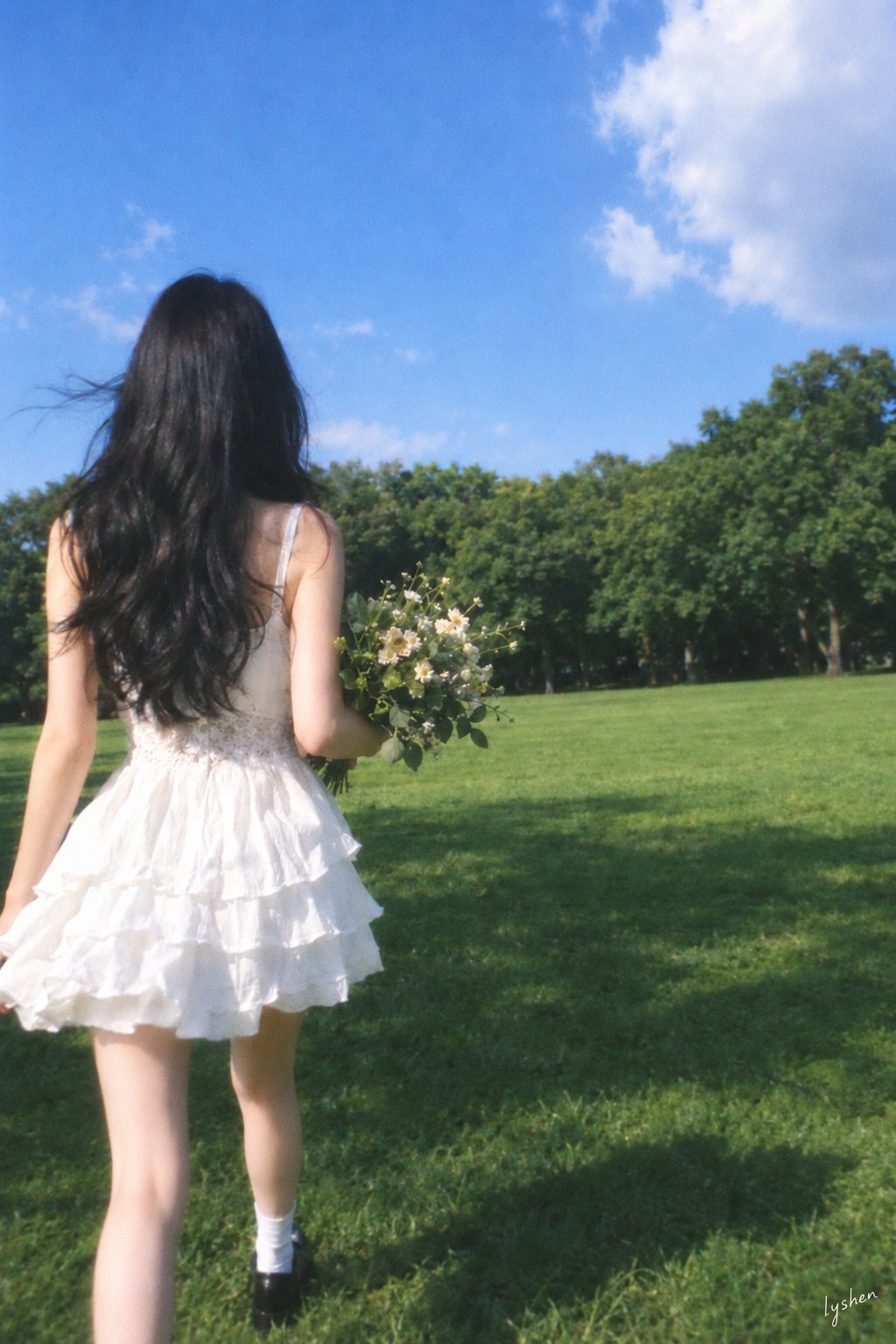 画幅与构图:约2:3竖幅;人物在画面左侧三分之一附近,头顶落在上方约三分之一高度;上方大片天空,右侧较多草地;腿部延伸至