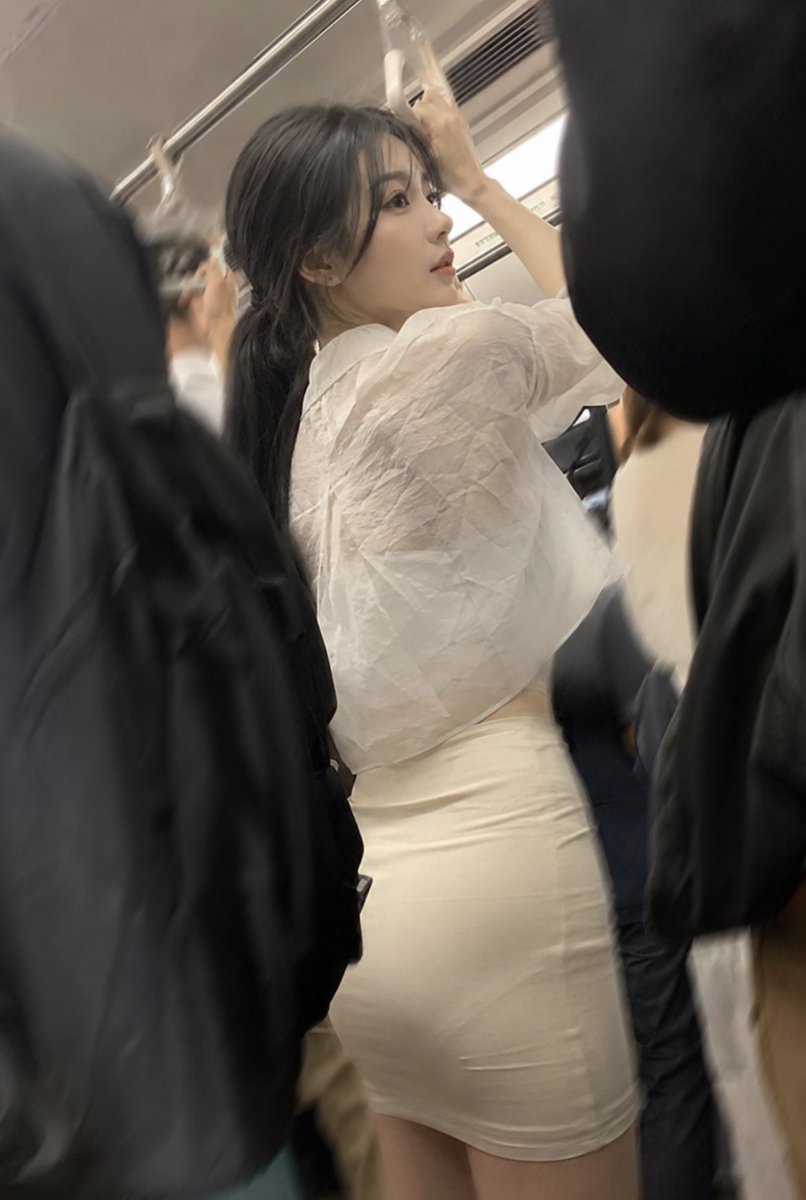 请根据主题“拥挤的通勤地铁上，一位惊艳的女子，让人忍不住多看一眼”创作一幅图像。